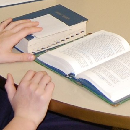 image of child's hand resting on a book